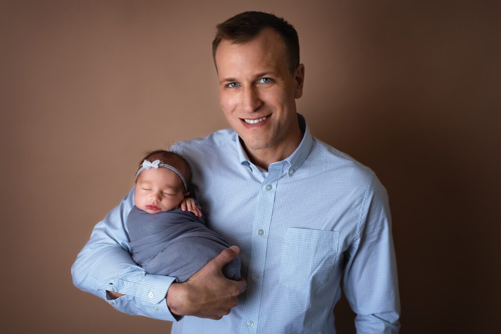 proud dad photo holding newborn daughter in San Elijo Hills, CA